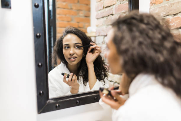 istock Everything should be perfect. Attractive young woman doing make-up while looking at the mirror and smiling 1168036684