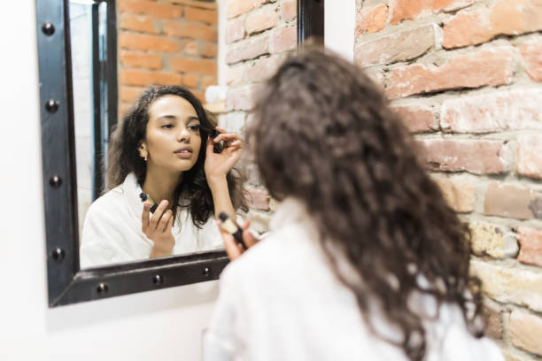 istock Everything should be perfect. Attractive young woman doing make-up while looking at the mirror and smiling 1168036789
