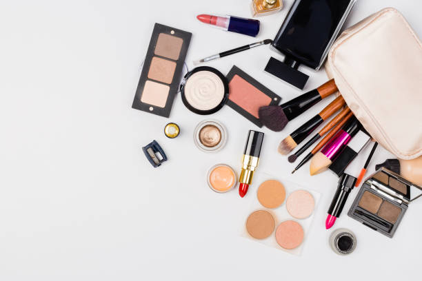 istock Makeup products with cosmetic bag and macaroons on light background 1168039918