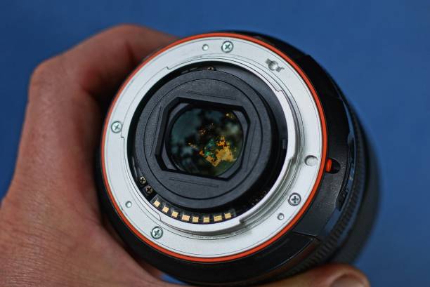istock camera lens in a hand on a blue background 1168045806
