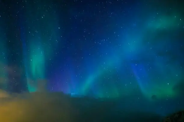 Photo of Aurora Borealis Known as Nothern Lights Playing with Vivid Colors Over Lofoten Islands in Norway. Horizontal Image Orientation