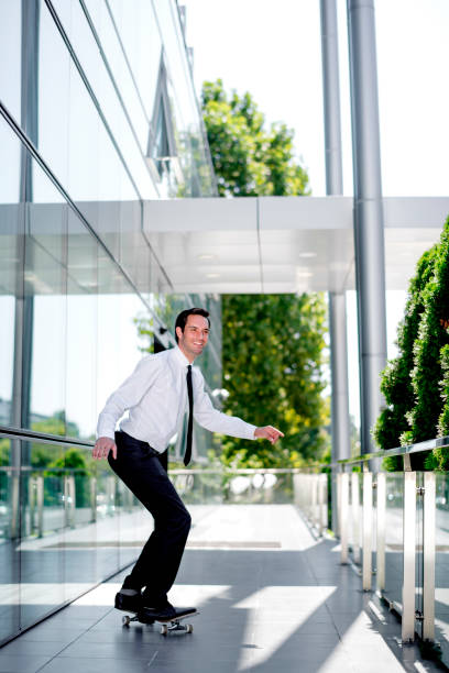 istock Handsome businessman riding skateboard 1168047383