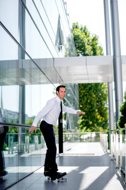 istock Handsome businessman riding skateboard 1168048935