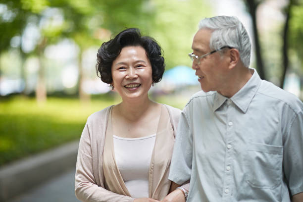 istock Cheerful Chinese Seniors Walking and Talking in Public Park 1168048968