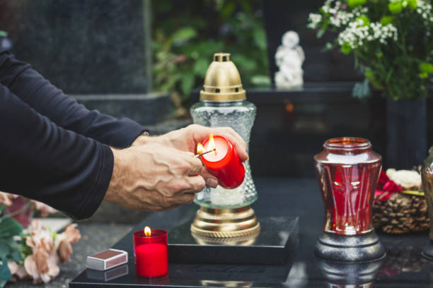 Lighting candle at graveyard during All Souls Day.