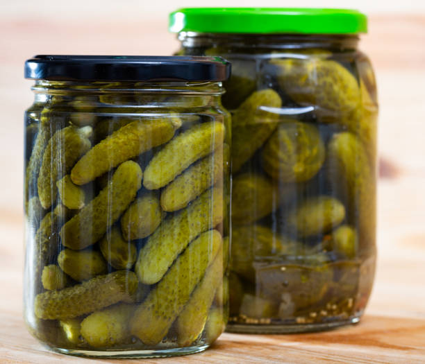 istock Glass jar with pickled cucumbers on a wooden table 1168053741