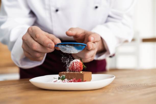 istock Close up pastry chef decoration delicious dessert dish, serving for customers in bakery, garnishing dessert plate in commercial kitchen. 1168055637