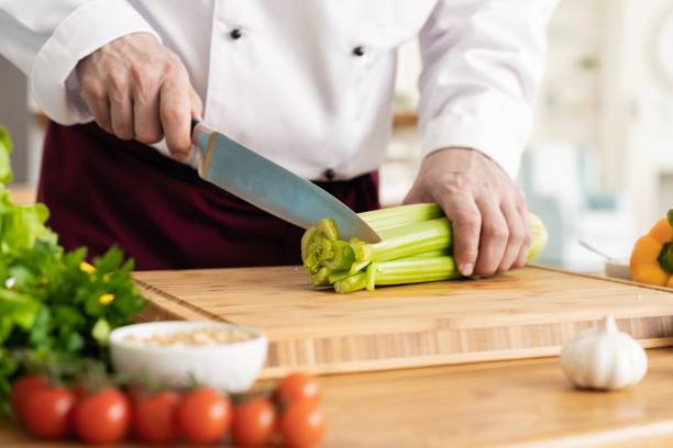 cozinheiro chefe que corta vegetais frescos e deliciosos para cozinhar. - hotel commercial kitchen organic salad - fotografias e filmes do acervo