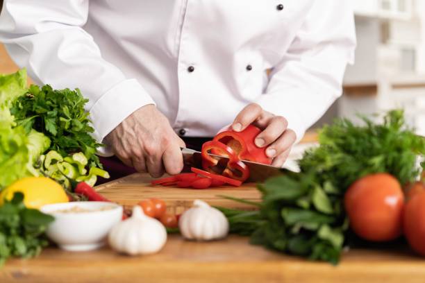 cozinheiro chefe que corta vegetais frescos e deliciosos para cozinhar. - hotel commercial kitchen organic salad - fotografias e filmes do acervo