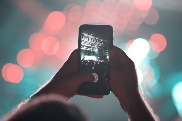 Filming my favorite band. Unrecognizable young man filming concert with his mobile phone. photo messaging stock pictures, royalty-free photos & images