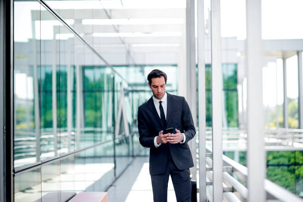 istock Young smiling businessman using mobile phone 1168062130