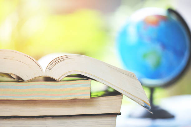 istock Education concept back to school and business study global world - open book in the table with book stacked and earth globe model map 1168073603