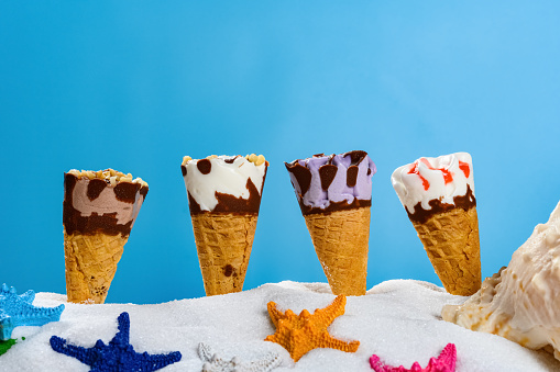 white sand with different ice cream cones and starfishes concept of summer holidays