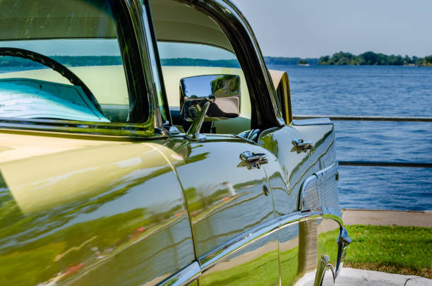 vista a quarto a destra di un'auto d'epoca gialla di fronte a un fiume - retro revival cruise hood car foto e immagini stock
