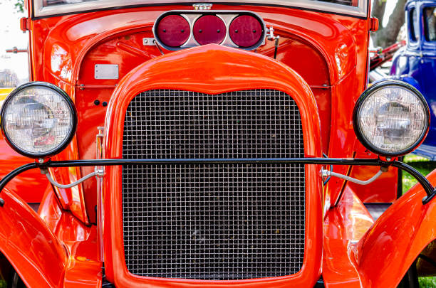 Symmetrical Front view of a red hot rod with grill, headlights and supercharger intake. Symmetrical Front view of a red hot rod with grill, headlights and supercharger intake. cruising hot rods stock pictures, royalty-free photos & images