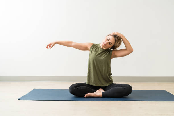 フィットネストレーニングセッションでエクササイズする女性 - stretching yoga exercise mat women ストックフォトと画像