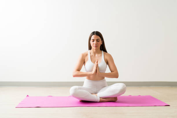 istock Fit Woman Sitting In Easy Pose Against Wall 1168076489