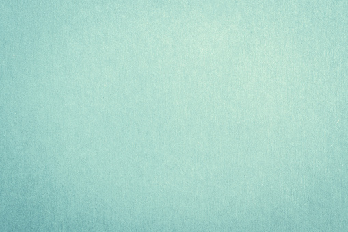 Recycled craft paper textured background in light green cyan blue color