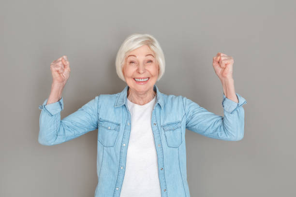 istock Senior woman in jeans jacket studio isolated on grey wall winner 1168079907