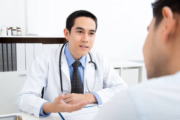 istock Asian doctor talking with male patient 1168079995