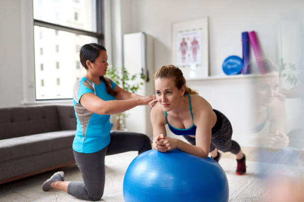 istock Chinese woman personal trainer during a workout session with an attractive blond client in a bright medical office 1168080056