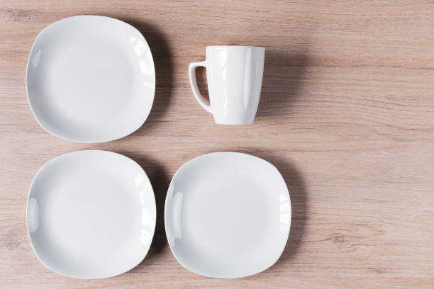 istock White ceramic cups and plates on wooden background, image 1168084127