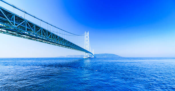 пейзаж моста акаси кайкио на фоне голубого неба летом утром - kobe bridge japan suspension bridge стоковые фото и изображения