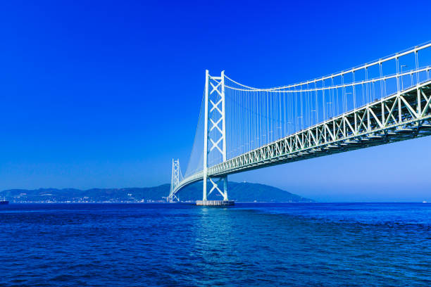 пейзаж моста акаси кайкио на фоне голубого неба летом утром - kobe bridge japan suspension bridge стоковые фото и изображения