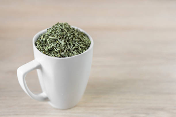 istock white cup with moringa leaves on wooden background 1168085287