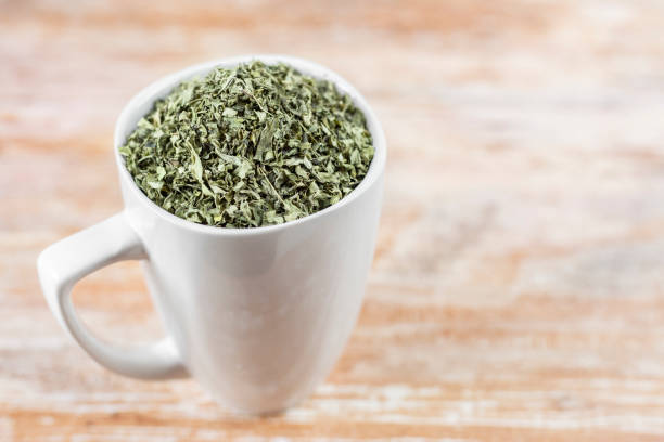 istock white cup with moringa leaves on wooden background 1168085312