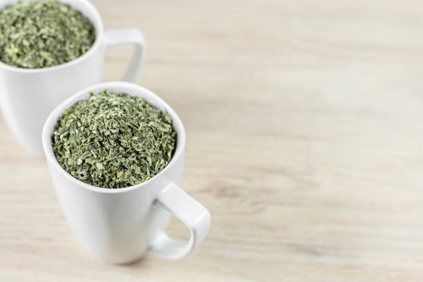 istock white cup with moringa leaves on wooden background 1168085326