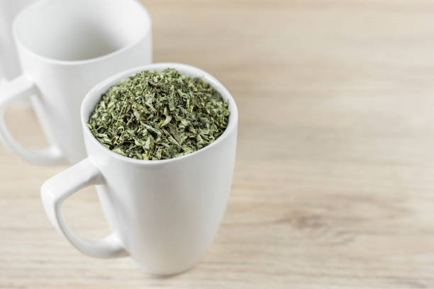istock white cup with moringa leaves on wooden background 1168085377