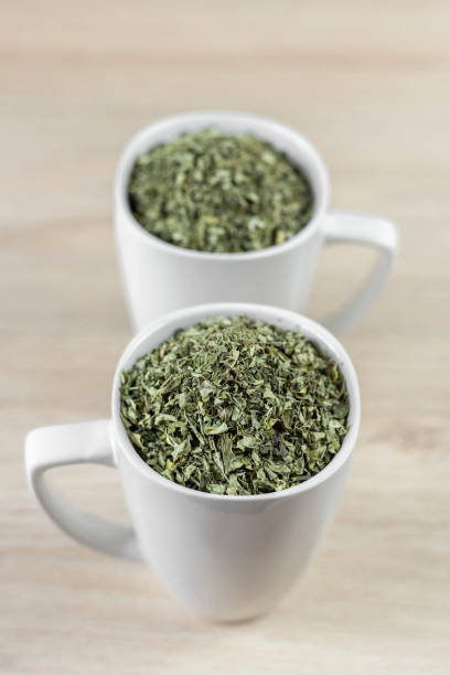 istock white cup with moringa leaves on wooden background 1168085378