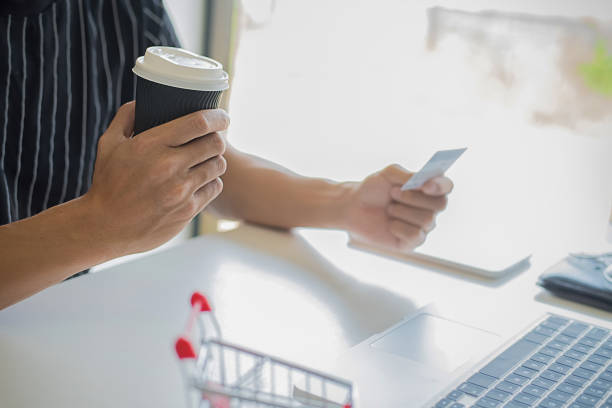 istock Young man holding credit card and using laptop computer. Online shopping concept 1168088199