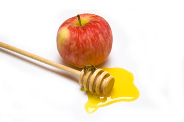 istock honey spoon, liquid honey and bee near Apple selective focus 1168089600