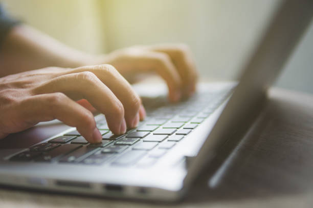istock Working at home with laptop man writing a blog. Man hands on the keyboard 1168089609