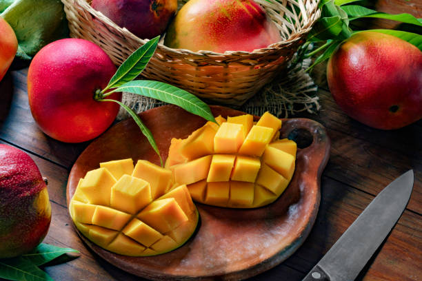 istock Tropical Fruits: Sliced mangos in a clay rustic plate on a wooden table in rustic kitchen 1168090747