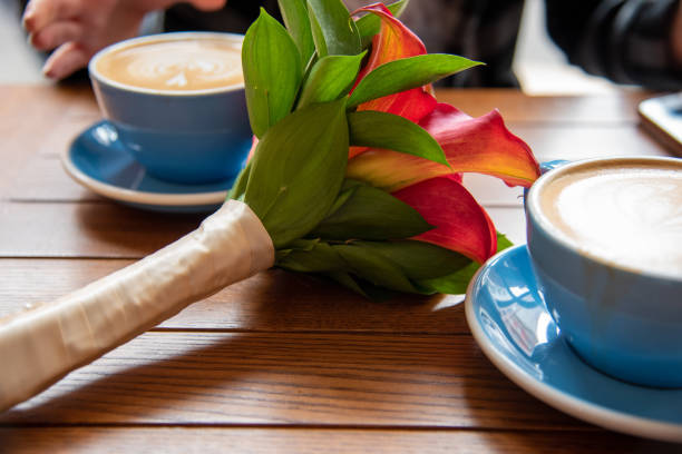 cappuccino sur une tasse bleue par un bouquet de fleur - connection usa coffee cup mug photos et images de collection