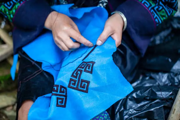 embroidery with patterns on clothes close-up, woman's hands embroidering a pattern on fabric