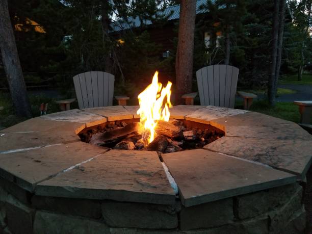 Campfire in stone fire pit in campground at night Campfire in stone fire pit in campground at night fire pit photos stock pictures, royalty-free photos & images