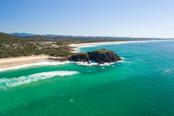 aerial of headland on the coast with inviting water, sunrise, blue water for swimming and surfing. family or retiree destination in summer holiday. cabarita beach in queensland - cabarita beach imagens e fotografias de stock