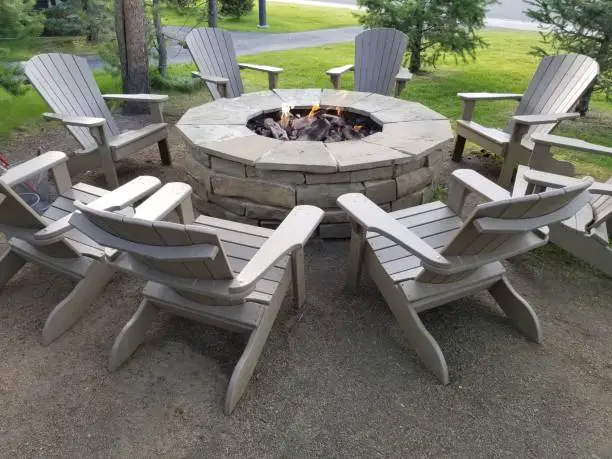 Meeting place around circular brick fire pit with Adirondack chairs in park area