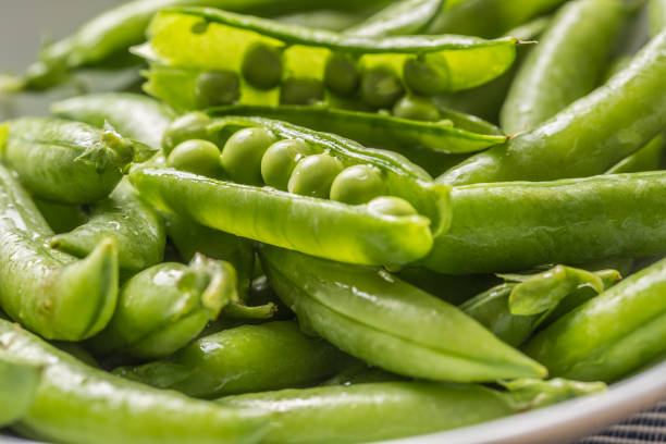 istock Fresh green pea seeds and pods - Close up 1168107781