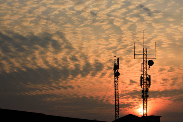 Image of Telecommunication tower antenna with sunset background.