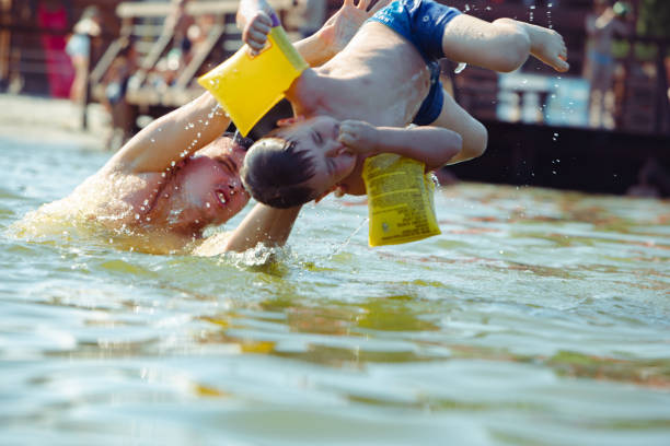 istock father throwing son in water having fun 1168113025
