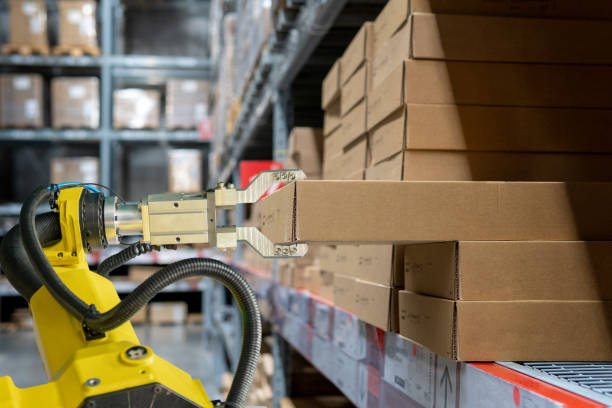 istock yellow robotic arm carry cardboard box in warehouse 1168115867