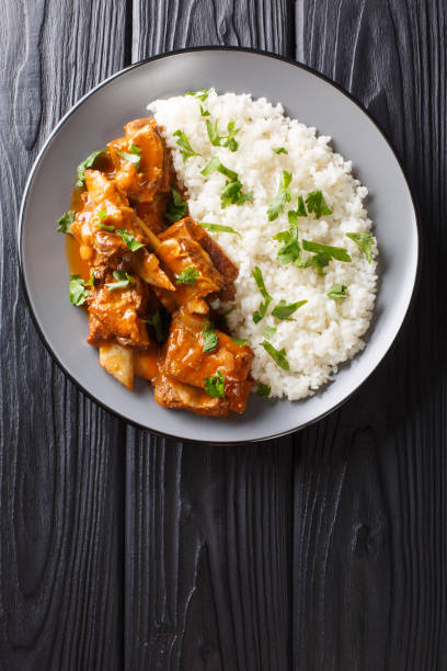 istock Stewed ribs in a spicy sauce served with white rice close-up. Vertical top view 1168117742