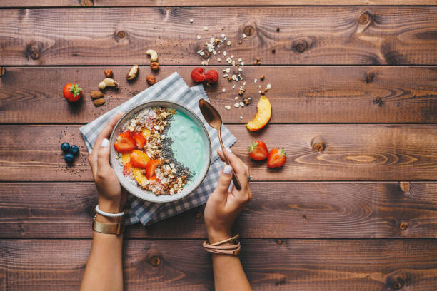 mujer comiendo un tazón de batido saludable - chia seed spoon food fotografías e imágenes de stock