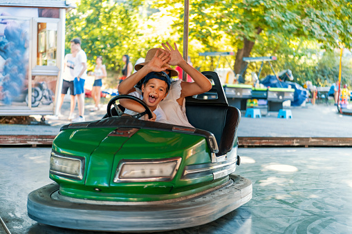 Mother and her son having fun while driving bumper car