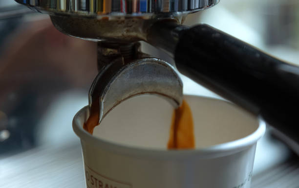istock Coffee machine console.Coffee machine handle and paper cup in white. Paper cups are waiting for coffee to come out. One of the steps to make coffee 1168122258